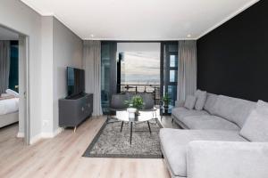 a living room with a couch and a television at 16 on Bree Modern 2BR Luxury Apartment in Cape Town +35 photos