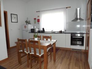 a kitchen with a wooden table and chairs in a kitchen at The Music House, Ilha Terceira, Açores in Praia da Vitória