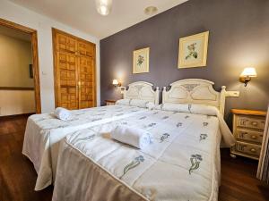 a bedroom with a large bed with towels on it at Apartamentos Casa Boira 3000 in Gavín