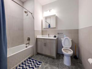 a bathroom with a toilet and a sink and a tub at 313 brand new 3 bedroom 2 bath in Dunellen