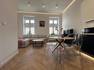 a living room with a couch and a table and chairs at Goldhammer Premium Apartments in Tarnów