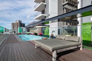 a couch sitting on the deck of a building at 16 on Bree Modern 2BR Luxury Apartment in Cape Town