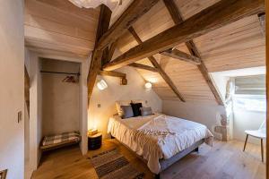 a bedroom with a large bed in a room with wooden ceilings at Les Terrasses de Majorac in Bozouls +32 photos