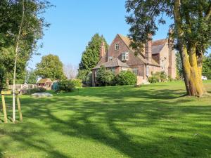 a large house with a tree in the yard at Goss Hall in Canterbury