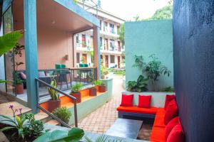 a patio with red pillows and a red couch at Explorers Hub in Kampala