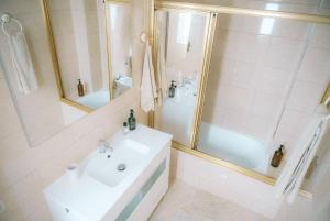 une salle de bain blanche avec lavabo et douche dans l'établissement Luxury Beachfront Penthouse with Stunning Views, à Las Palmas de Gran Canaria 26 autres photos