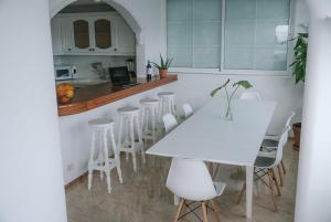 une cuisine avec une table blanche et des tabourets blancs dans l'établissement Luxury Beachfront Penthouse with Stunning Views, à Las Palmas de Gran Canaria