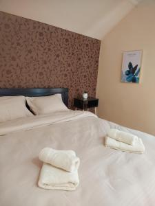 a bedroom with a white bed with two towels on it at Stan na dan PREMIUM 2 apartman in Obrenovac