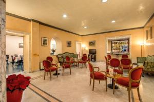 a living room with red chairs and a dining room at Hotel San Remo in Rome