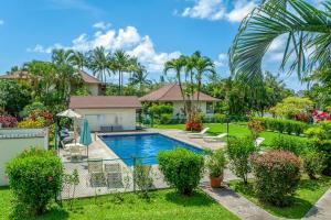 a house with a swimming pool in a yard at Paniolo 210B in Princeville