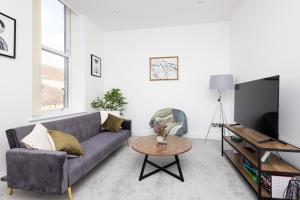 a living room with a couch and a table at Harrogate Haven by Luxus in Harrogate