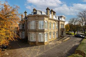 a large building with white windows on a street at Harrogate Haven by Luxus in Harrogate