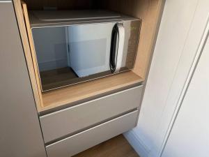 a microwave oven in a cabinet in a kitchen at studio 1104 Teresa WBE · Studio/sp/prox Allianz Parque/Puc/espaço américas in Sao Paulo