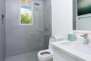 a white bathroom with a toilet and a shower at Westmoreland Modern sea View Villa with pool in Saint James +16 photos