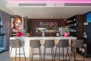 a bar with four stools in front of a counter at 16 on Bree Modern 2BR Luxury Apartment in Cape Town