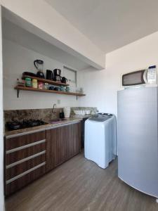 a kitchen with a white refrigerator and a counter at Apartamento Dona Elvira in Piçarras +49 photos