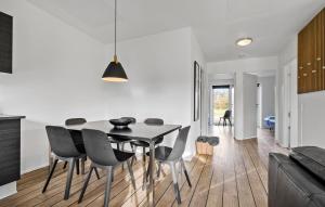 HeeにあるHoliday Home Dyrefolden Ringkøbing Denmの黒いテーブルと椅子のあるダイニングルーム