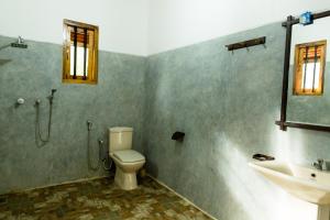 a bathroom with a shower and a toilet and a sink at Sunshadow Chalet in Tangalle