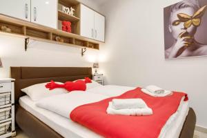 een slaapkamer met een bed met rode en witte handdoeken bij B&B Apartments Coli apartments Ema & Antigona self check on the ground floor in Bakar
