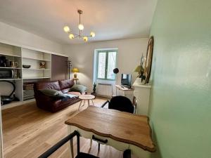 ein Wohnzimmer mit Tisch und Couch in der Unterkunft Appartement entre plage de l'Ecluse et place du marché in Dinard
