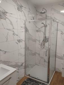 a shower with a glass door in a bathroom at Pokoje u Ewy in Limanowa +23 photos