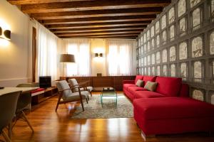 威尼斯Ca' della Scimmia - Rialto - Venice的客厅里有一张红色沙发和一张桌子。
