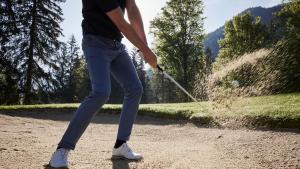 a man hitting a ball with a golf club at Der Brandstetterhof - Adults only in Stans