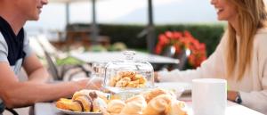 a couple sitting at a table with a plate of food at Agriturismo B&B Casa Bortolin in Valdobbiadene