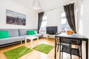 - un salon avec un canapé et une table dans l'établissement Apartments Mönchengladbach, à Mönchengladbach