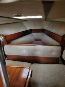 an empty train room with benches and a table at Bateau Jeanneau fantasia 8m à louer in La Rochelle