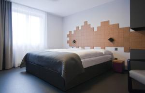 a bedroom with a large bed and a window at Hotel Rebstock - Self Check-in in Wolhusen