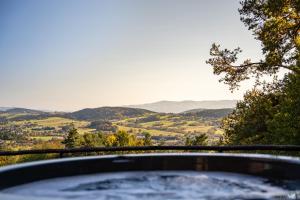 a hot tub with a view of the mountains at Łysogórska Polana Domki in Mordarka