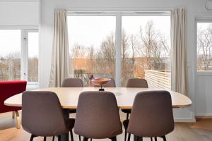a conference room with a table and chairs and a large window at Arctic Aurora Apartment I SAUNA I Family & Groups in Tromsø