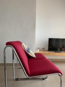 a red chair sitting in front of a desk at La Calita del Versalles in Faro de Cullera