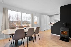 a dining room with a table and chairs and a stove at Arctic Aurora Apartment I SAUNA I Family & Groups in Tromsø +17 photos