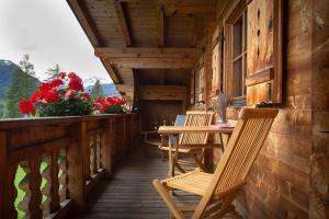une véranda avec des chaises et une table dans l'établissement apart strolz, à Sankt Anton am Arlberg
