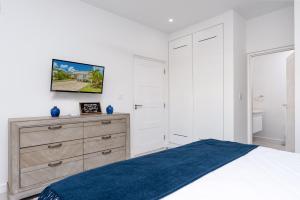 une chambre blanche avec un lit et une commode dans l'établissement West Coast 2 Bed Sea View Westmoreland Hills Villa, à Saint James