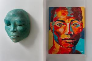 une peinture d'un visage et d'un masque sur un mur dans l'établissement West Coast 2 Bed Sea View Westmoreland Hills Villa, à Saint James