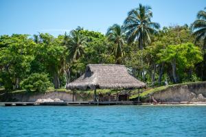 a hut on the shore of a body of water at Hotel Coral Sand Islas Del Rosario in Isla Grande