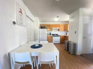 a kitchen with a white table and white appliances at Private BR,BA,KIT, LR 9 Mins to Beach in Edgemere