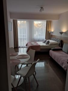 a hotel room with two beds and a table and chairs at Apartamenty Planeta 105, 108 Mielno - parking w cenie pobytu in Mielno