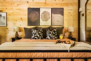 1 dormitorio con 1 cama grande con cuadros en la pared en Modern Cabin - The Emerald Nest, en Sevierville