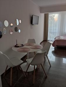 a room with a table and chairs and a television at Apartamenty Planeta 105, 108 Mielno - parking w cenie pobytu in Mielno
