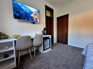 a room with a desk and two chairs and a tv at Apartments Miš in Trebinje