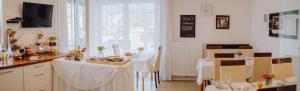 a dining room with two tables with white table cloth at Pension Sterntaler in Rheinhausen +9 photos
