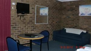 a room with a table and a tv and a couch at Tooleybuc Motel in Tooleybuc