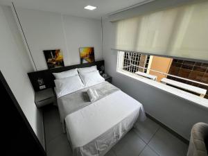 a small bedroom with a bed and a window at Flat Moderno completo Ar Consulado USA Cinelândia Centro - Feito por Arquiteto in Rio de Janeiro