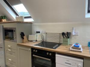 a kitchen with a stove and a counter top at Bakers Cottage in Ironbridge