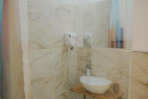 ein Badezimmer mit einem weißen Waschbecken und einem Spiegel in der Unterkunft Pensiunea Subcarpati in Jiblea Veche + 35 Fotos