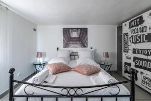 a bedroom with a white bed with two pillows at Appartement Cosy - Proche Disneyland - Paris - RER in Noisy-le-Grand
